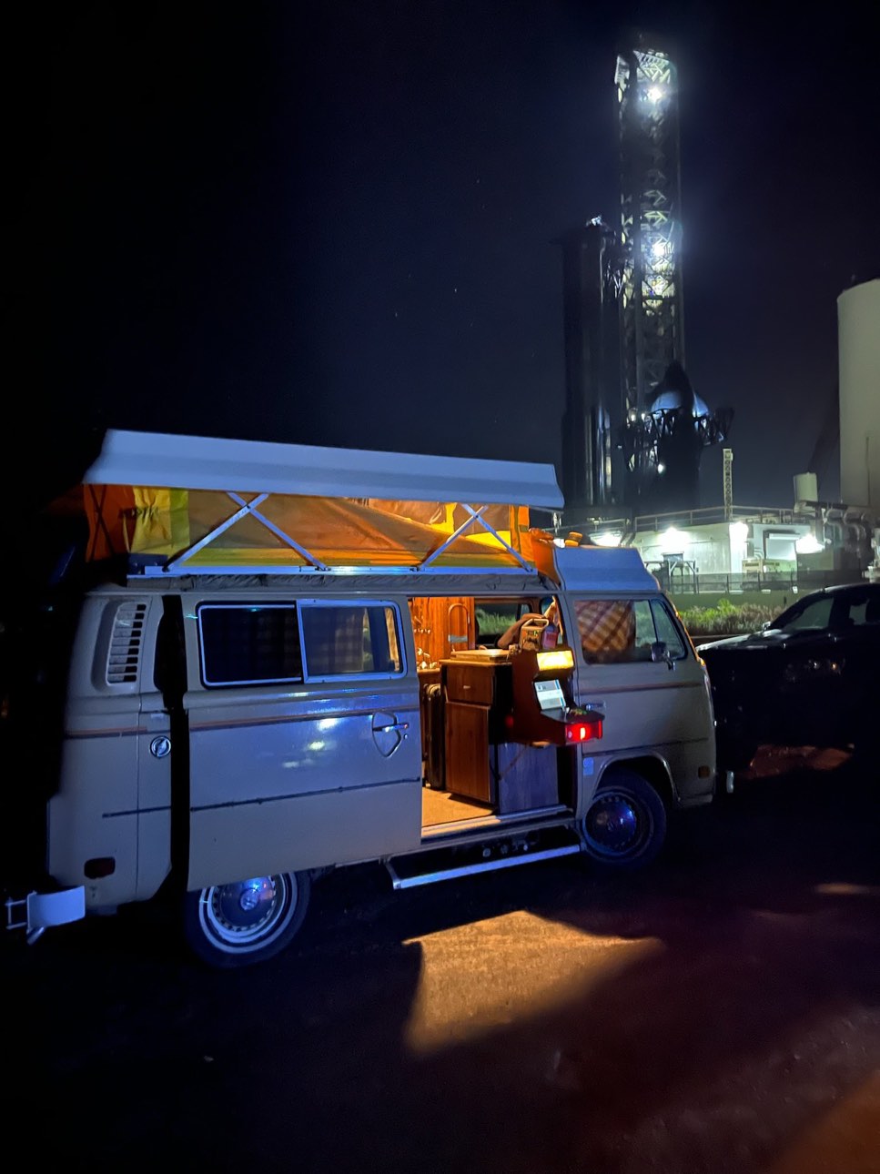 VW Riviera Type 2 conversion van at night with pop-top